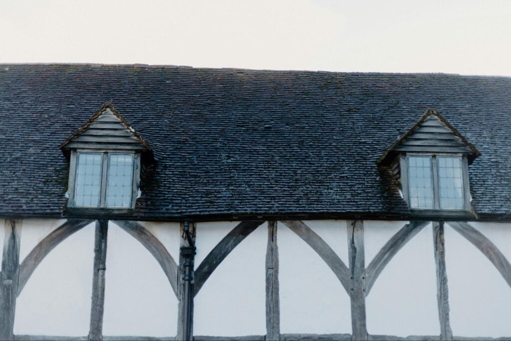 Steep residential roof with dark shingles and dormer windows, highlighting material choices for durability in varying climates like Tampa Bay.