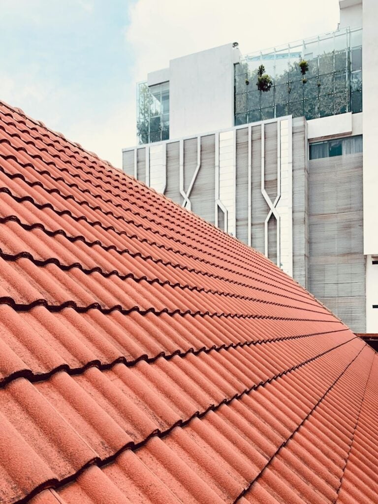 Close-up of a red tile roof, highlighting the durability, aesthetic appeal, and long-lasting performance of tile and synthetic roofing materials.

