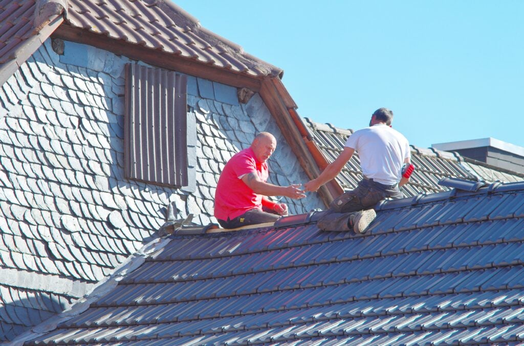 Roofers installing modern energy-efficient roofing materials designed to improve insulation, reflect heat, and reduce cooling costs. Roofers installing modern energy-efficient roofing materials designed to improve insulation, reflect heat, and reduce cooling costs.