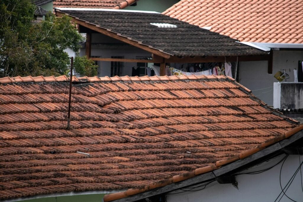 Weathered clay tile roofing with visible wear and debris buildup, showing conditions that can influence roof leak repair costs in Tampa Bay homes.
