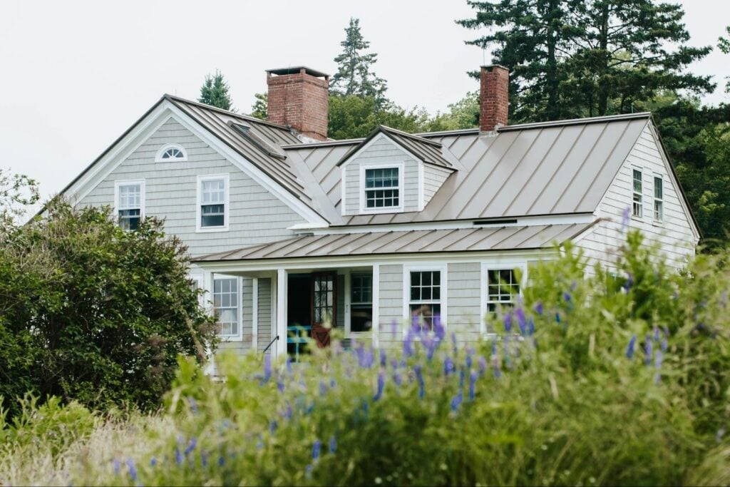 Residential home with a durable metal roof, illustrating how choosing cost-effective roofing materials can help manage project budgets while maintaining long-term protection.