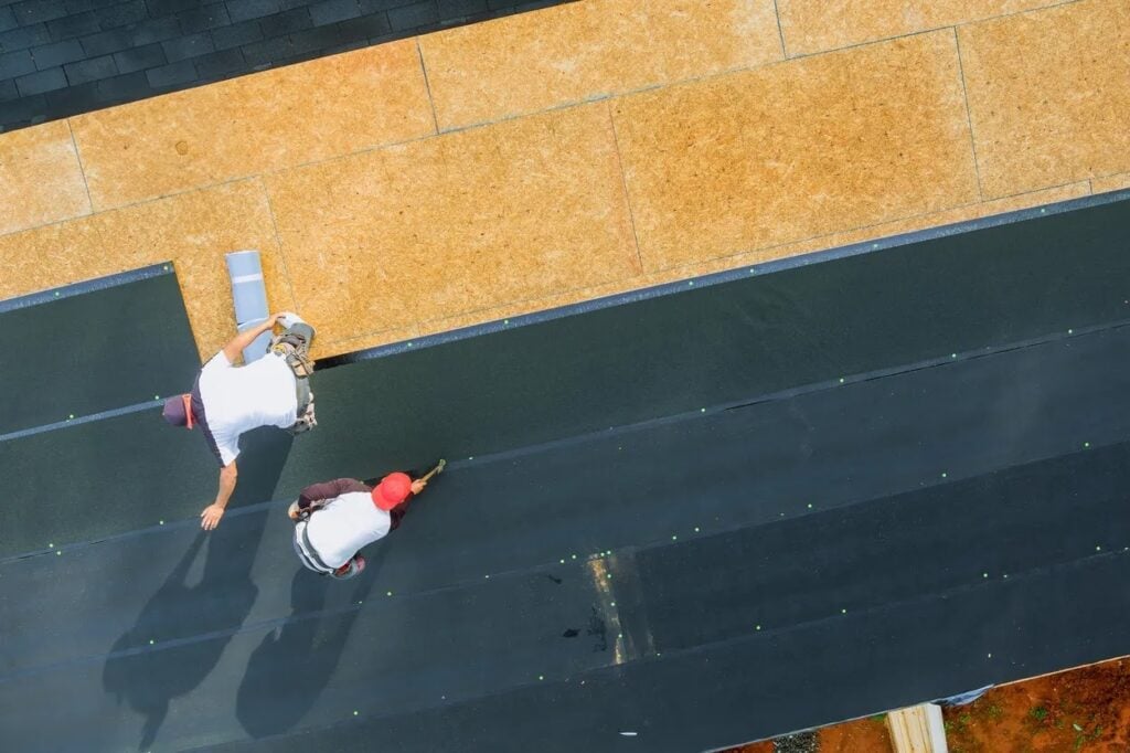Roofers installing durable roofing materials on a residential roof, highlighting materials designed to withstand Tampa’s heat, humidity, and storm conditions.