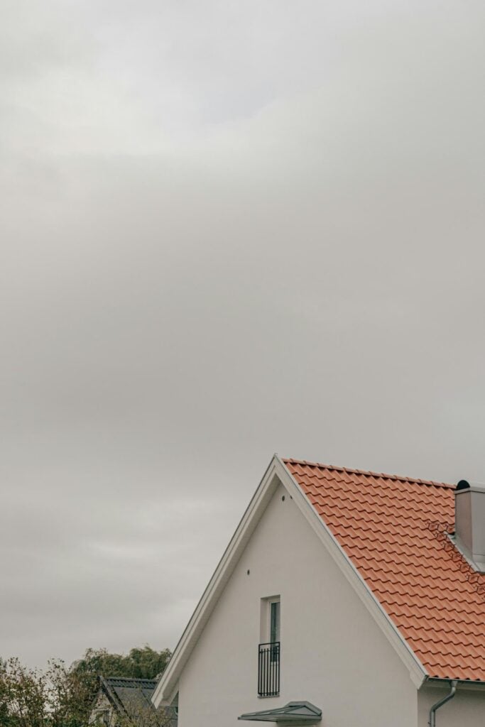 Home with a tiled roof under cloudy skies, illustrating how Tampa Bay’s weather conditions influence roofing material selection for durability and storm resistance.