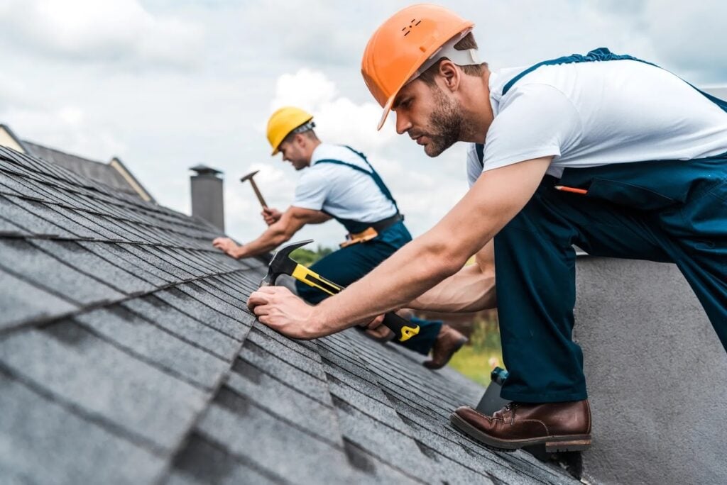 Roofing professionals repairing shingles on a residential roof, illustrating how GenX Roofing addresses common Tampa roof problems such as leaks, storm damage, and worn materials. Roofing professionals repairing shingles on a residential roof, illustrating how GenX Roofing addresses common Tampa roof problems such as leaks, storm damage, and worn materials.