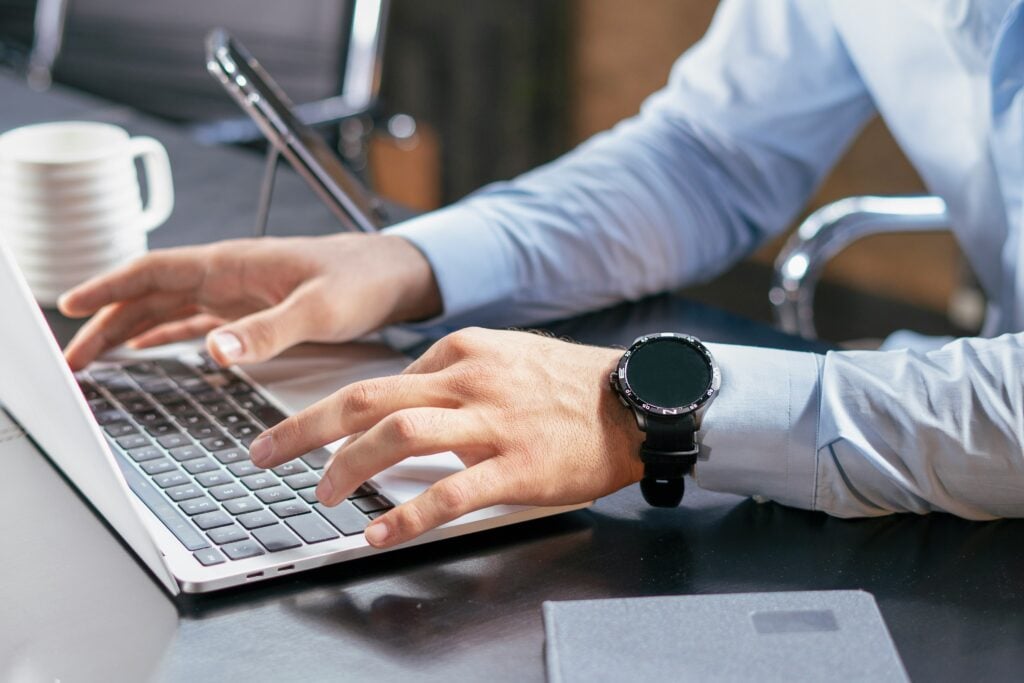 Person typing on laptop to verify roofing contractor licensing and insurance information
